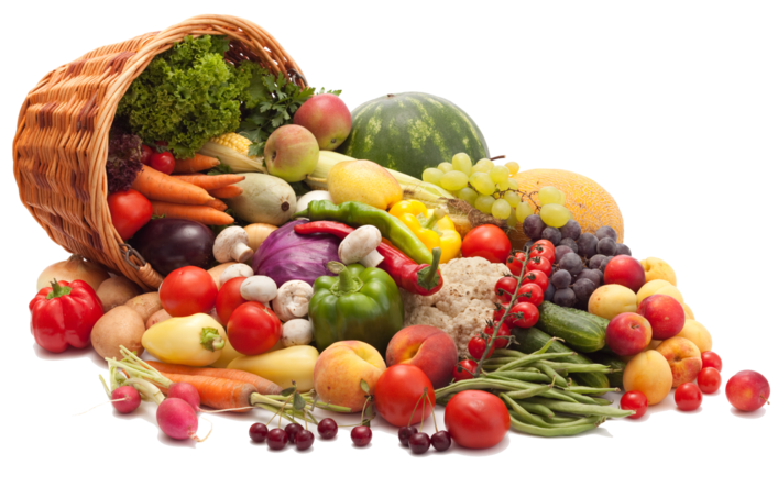 A wicker basket is laying on its side. A wide assortment of fruits and vegetables appear to have spilled out of the basket, cornucopia-style.