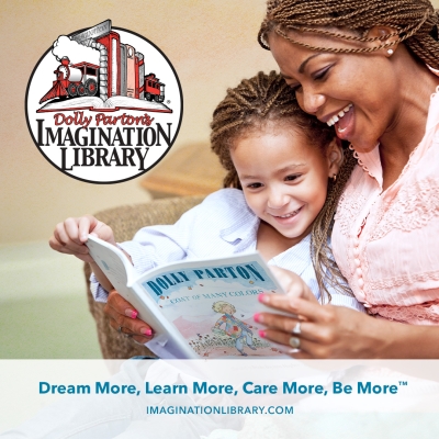 A woman is reading a book to a child.