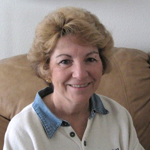 A woman with blonde hair is smiling.