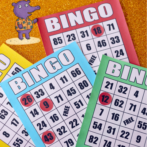 Multicolored Bingo cards and red marker chips on a table.
