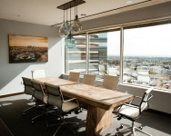 Long table surrounded by chairs on each side looking out over a city